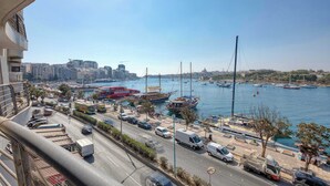 A coastal cityscape with a marina, boats, and a busy road. - Sliema 3BDR Flat with Seaview (Tas-Sliema)
