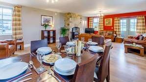 A dining area with a stone fireplace, a television, and a view of the outdoors. - 3 Bed in Consett (oc-29408) (Lanchester)