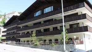 A multi-story building with balconies, a clear sky, and a street in the foreground. - Hof Arosa A-03 Appartement/Fewo,   4-Bettwohnung by Interhome (Arosa)