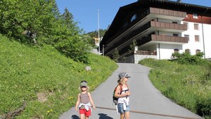 A pathway leading to a building with balconies, surrounded by greenery. - Hof Arosa A-03 Appartement/Fewo,   4-Bettwohnung by Interhome (Arosa)