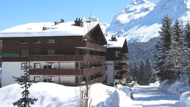 A multi-story hotel with balconies, snow-covered surroundings, and a mountain backdrop. - Hof Arosa A-03 Appartement/Fewo,   4-Bettwohnung by Interhome (Arosa)