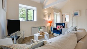 A living room with a television, sofa, armchair, and a window with a view of greenery. - 2 Bed in Shaftesbury (oc-28678) (Sedgehill)