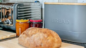 A kitchen with a toaster, a bread container, and two jars of jam. - 2 Bed in Truro (oc-36178) (Porthtowan)