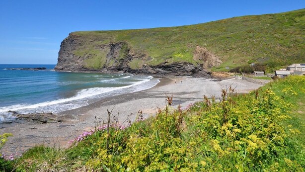 A coastal landscape with a cliff, beach, and greenery. - 1 Bed in Launceston (oc-36500) (Egloskerry)