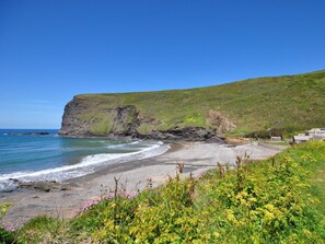 A coastal landscape with a cliff, beach, and greenery. - 1 Bed in Launceston (oc-36500) (Egloskerry)