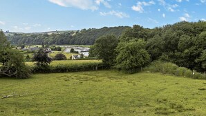 A rural landscape with a river, rolling hills, and a clear sky. - 2 Bed in Bideford (oc-36456) (Weare Giffard)
