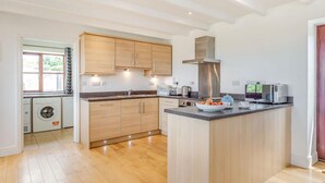 Une cuisine moderne avec des meubles en bois, un îlot central et des appareils électroménagers intégrés.