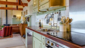 Une cuisine équipée d’une cuisinière, d’un évier et de placards.