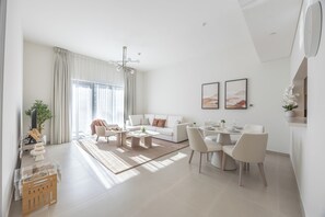 Una sala moderna con sofá, mesa de centro, comedor y televisor.