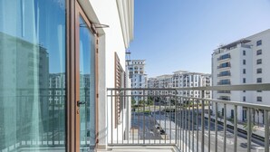 A balcony with a view of a cityscape, including buildings and a road. - Bloomfields 1BR in Yas Golf Collection  (Abu Dhabi)