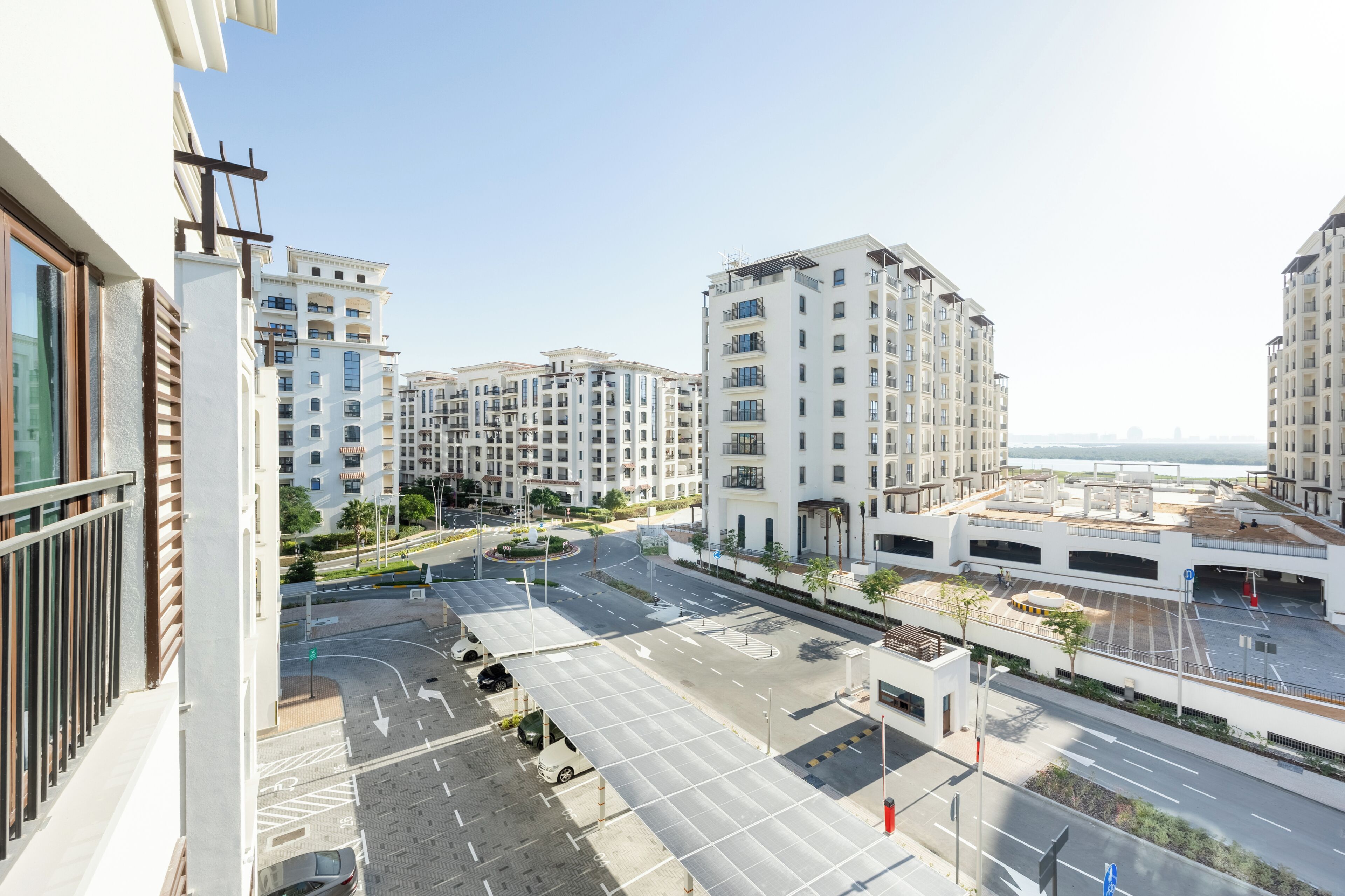 A modern urban residential area with multi-story buildings, a central roundabout, and a parking structure.