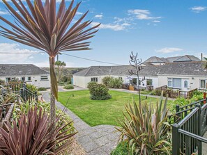 A residential area with houses, a well-maintained lawn, and a variety of plants. - 2 Bed in Helston (oc-36430) (Mullion)