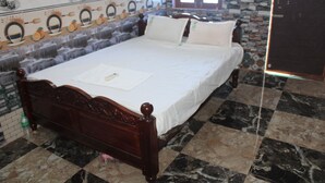 A room with a bed, a tiled wall, a window, and a door. - sri sakthivel santhamurugan residency (Tiruvannamalai)