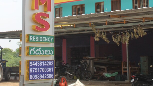A sign for a building with 'ROOMS' and 'RESIDENCY' written on it, along with contact numbers. - sri sakthivel santhamurugan residency (Tiruvannamalai)