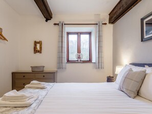 A bedroom with a bed, a window with curtains, a bedside table with a basket, and a wall-mounted picture. - 2 Bed in Tintagel (oc-36913) (Tintagel)