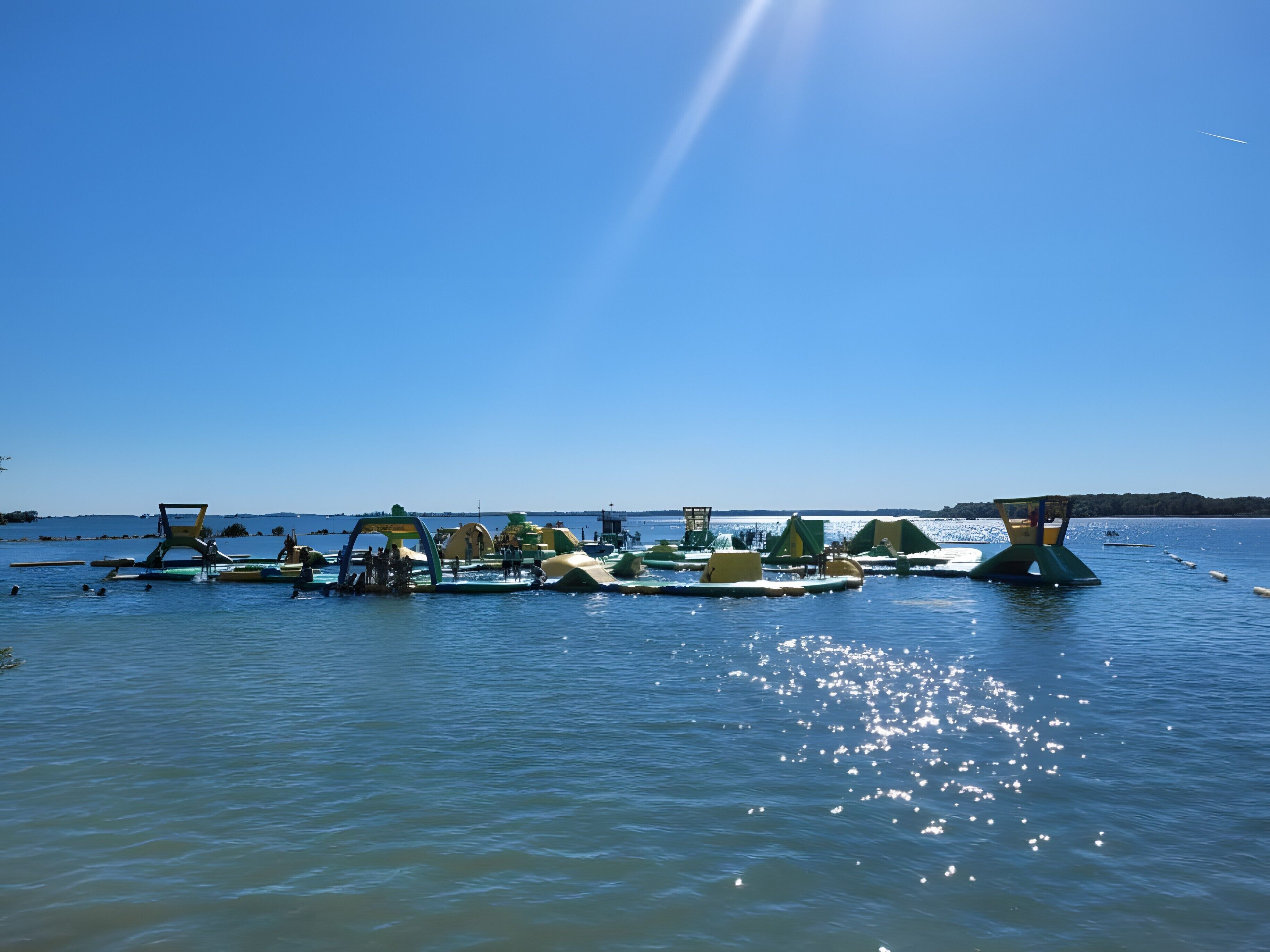 Un lac paisible où flottent des structures, probablement destinées à des activités de loisirs.