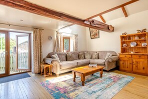 Ein gemütliches Wohnzimmer mit einem Ecksofa, einem Couchtisch und einem Holzkabinett.