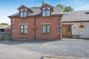 A two-story brick building with a gabled roof, a wooden door, and a small porch area. - 5 Bed in Preston (oc-40993) (Pilling)