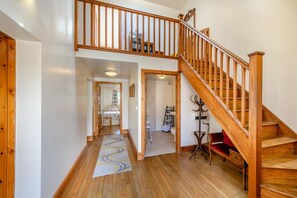 A wooden staircase leading to a second floor, a hallway with a patterned rug, and a bedroom with a bed and a window. - 5 Bed in Preston (oc-40993) (Pilling)