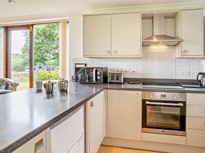 Eine moderne Küche mit weißen Schränken, einem Backofen, einem Kochfeld und einem Toaster.