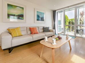 Ein modernes Wohnzimmer mit Sofa, Couchtisch und Bildern an den Wänden.
