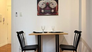 Ein Essbereich mit Tisch, zwei Stühlen und einem Wandbild.