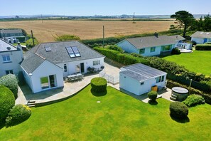 Un quartier résidentiel avec des maisons, une pelouse bien entretenue et une vue dégagée sur les champs environnants.