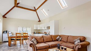 A spacious living area with a brown leather sofa, wooden coffee table, and a dining table with chairs. - 3 Bed in Taunton (oc-blaba) (Hillcommon)