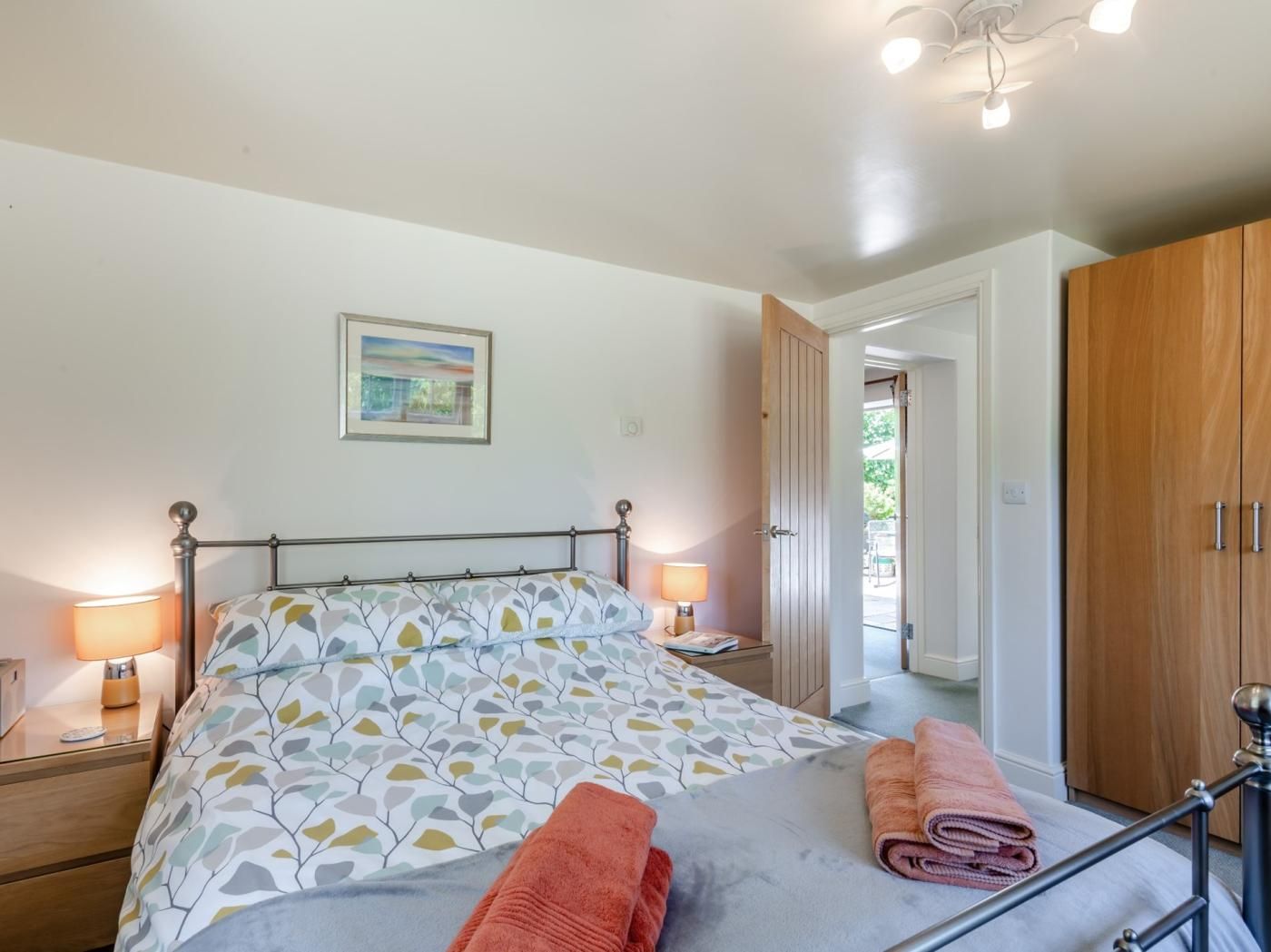 Une chambre à coucher avec un lit, des lampes de chevet, une porte et une armoire.