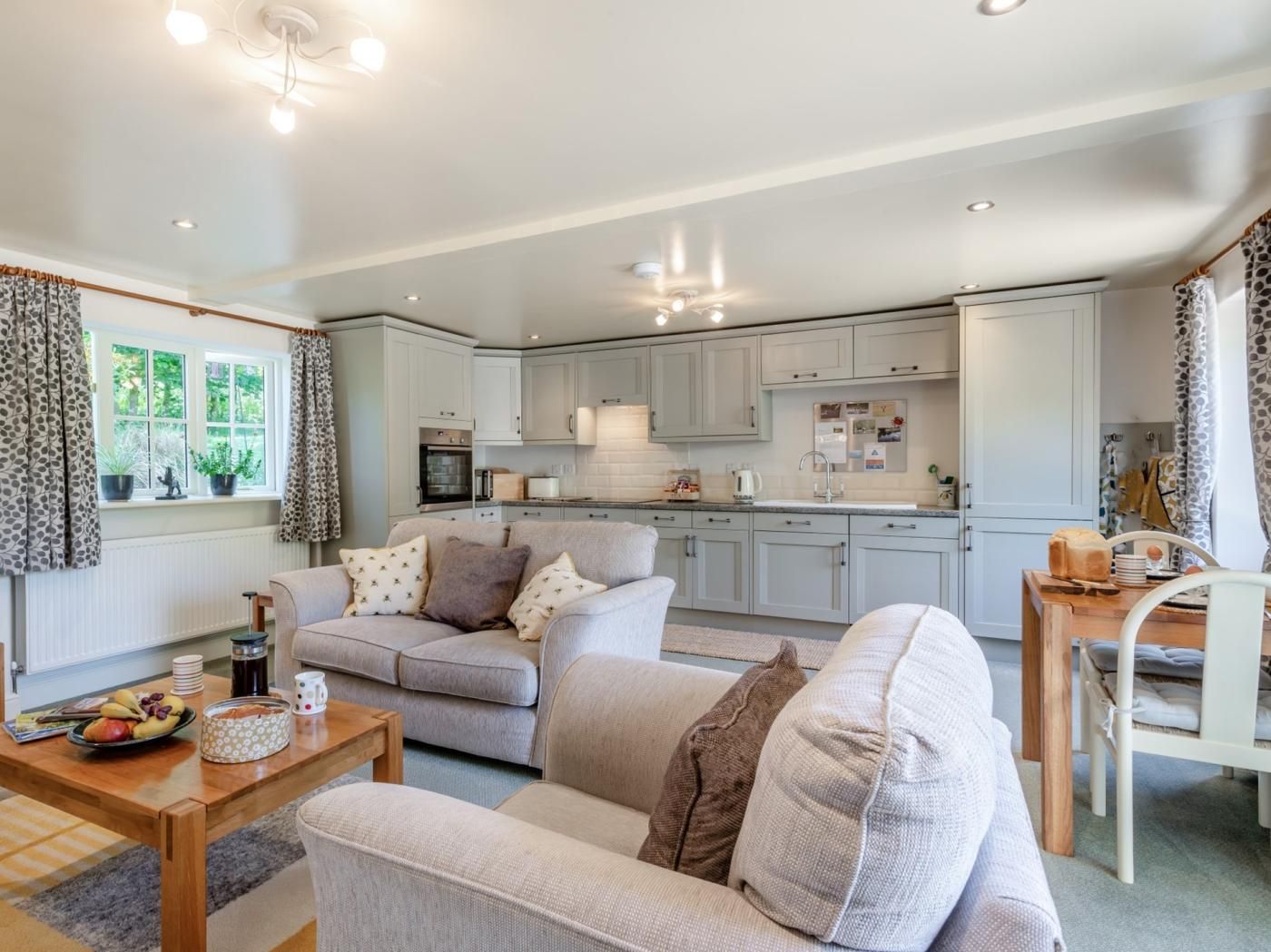 Un salon moderne comprenant un canapé, une table basse et un coin repas avec une chaise.