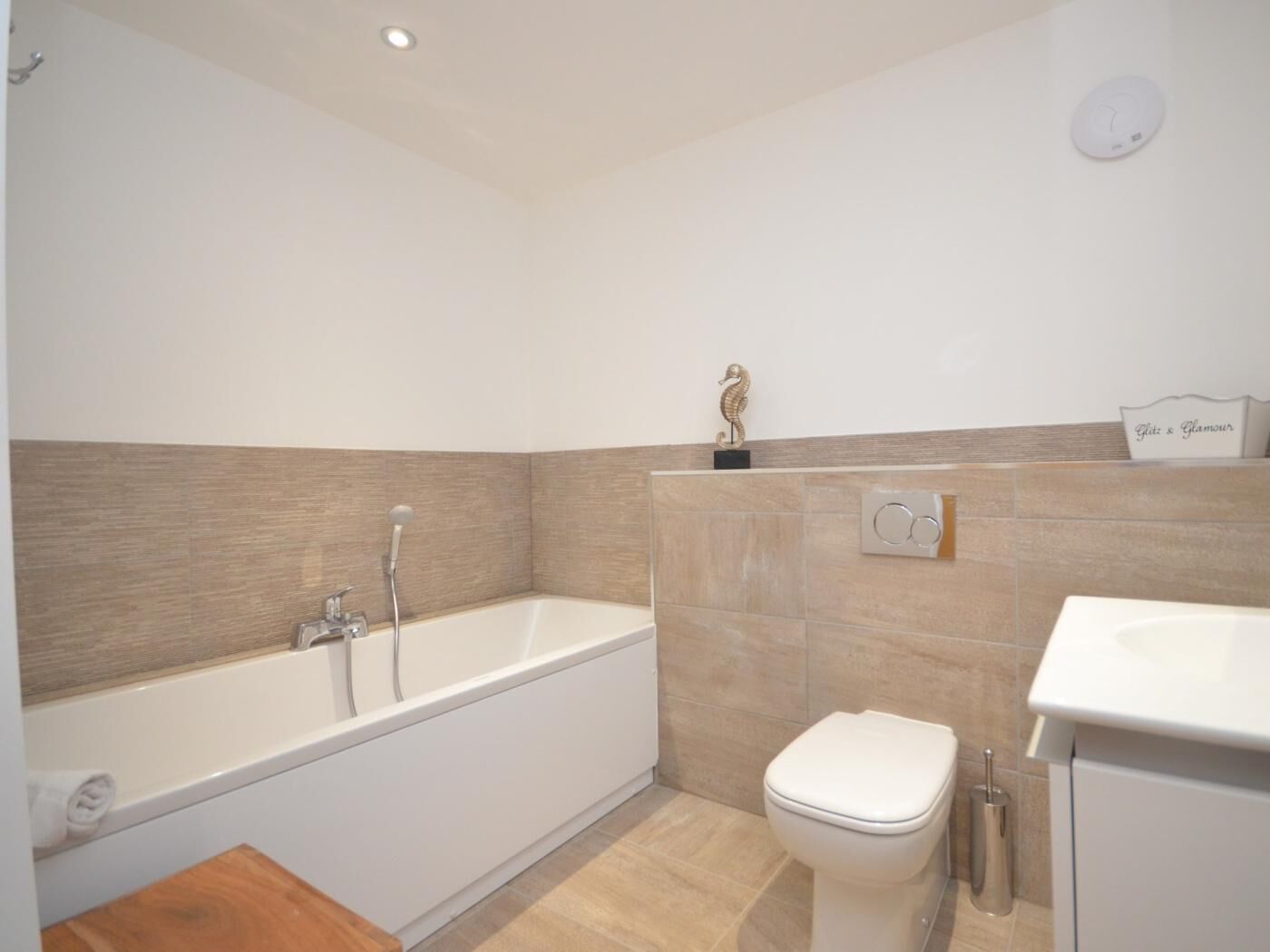 A modern bathroom with a bathtub, toilet, and vanity.