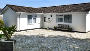 A single-story house with a tiled roof, a front door, and a bench. - 3 Bed in Redruth (oc-37014) (Saint Day)