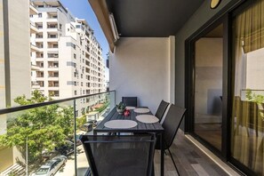 A balcony with a table, chairs, and a potted plant. - Kiti Apartment | Beach Escape by PikHost (Vlorë)