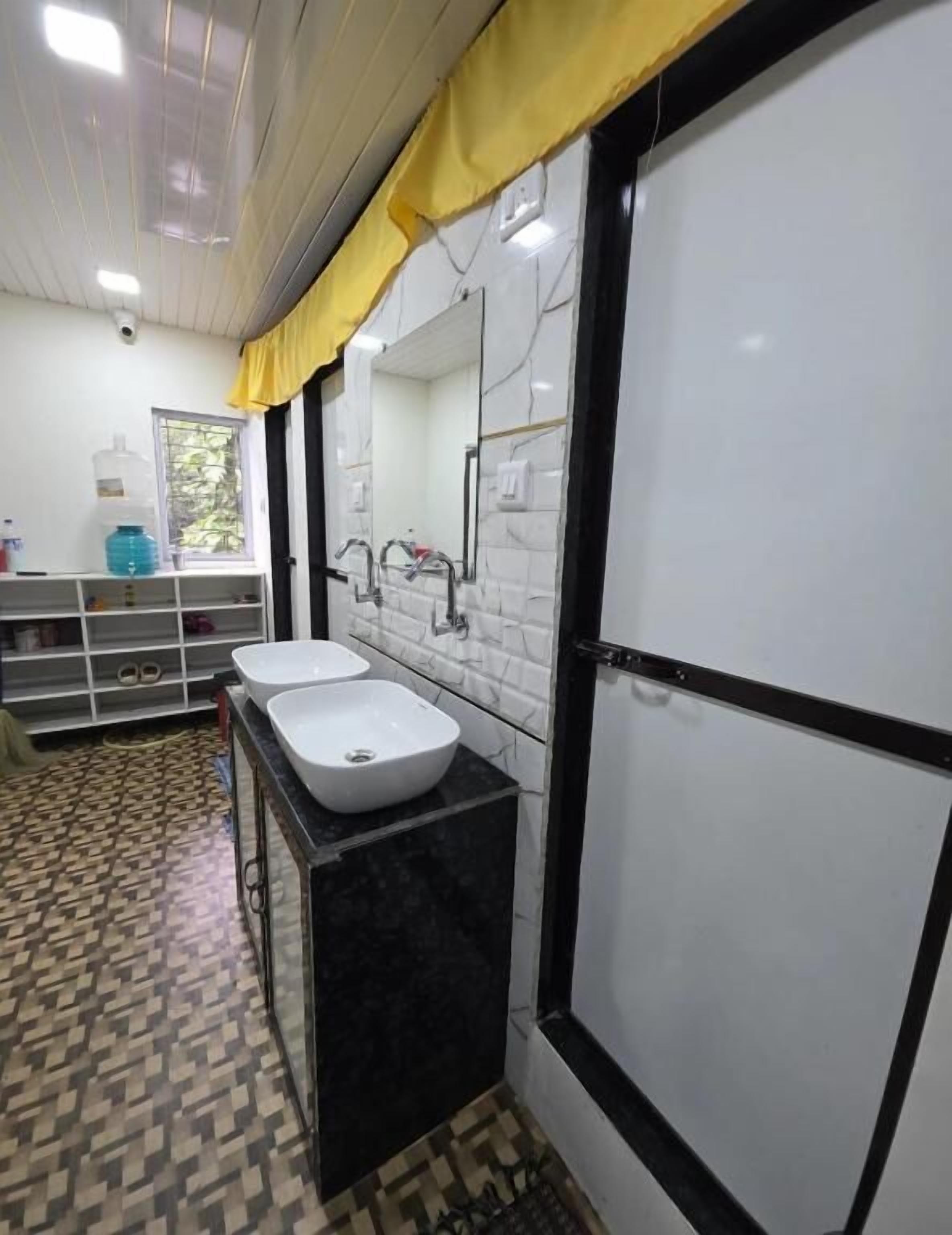 A bathroom with two sinks, a mirror, a towel rack, and a window.