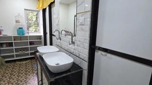 Une salle de bain avec deux lavabos, un miroir, un porte-serviettes et une fenêtre.