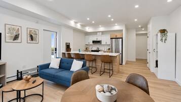 A modern apartment with a living room, kitchen, and dining area.