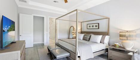 A modern bedroom with a four-poster bed, a ceiling fan, a television, and a nightstand with a lamp.