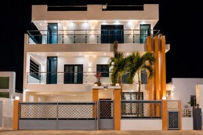 Un immeuble résidentiel à plusieurs étages, doté d’une entrée sécurisée, de balcons et d’une façade bien éclairée.