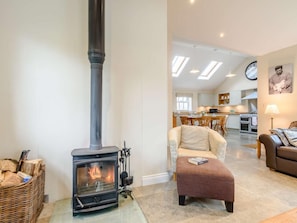 A living room with a wood-burning stove, a dining area, and a kitchen. - 1 Bed in Thirsk (oc-40354) (Sinderby)