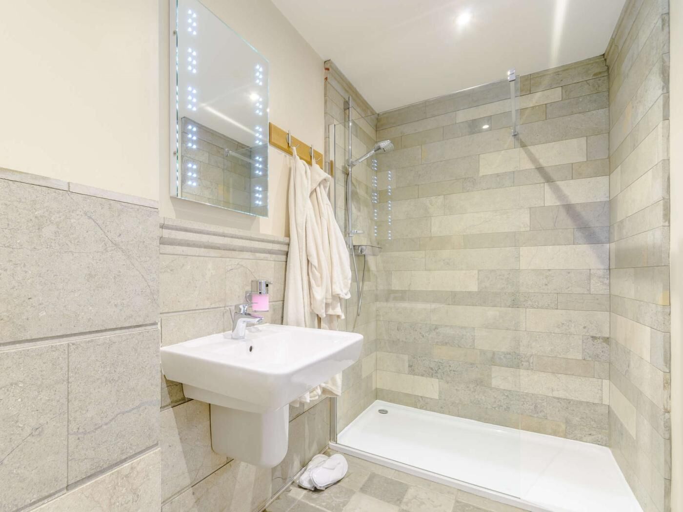 A bathroom with a sink, mirror, shower, and bathtub.
