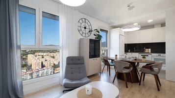 Un apartamento moderno con comedor, cocina y ventanas amplias con vistas a la ciudad.