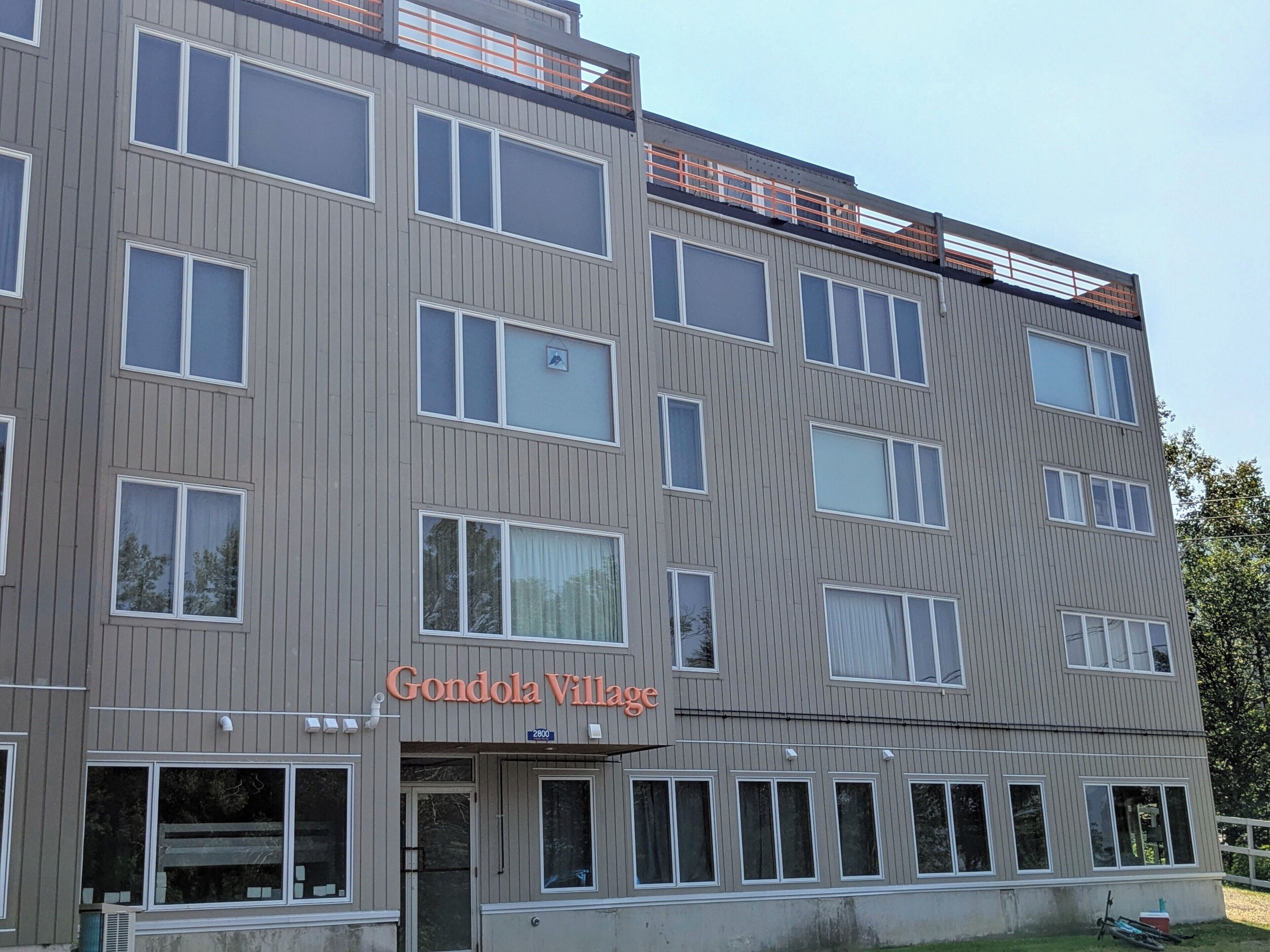 A multi-story building with a sign reading 'Gondola Village.'