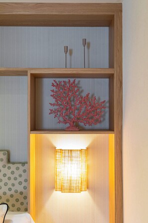Ein Zimmer mit einem Holzboden, einer roten Korallenverzierung und einer beleuchteten Lampe.