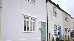 A row of white houses with distinct front doors, a black fence, and a small garden area. - 2 Bed in Wells (oc-41654) (Wells)