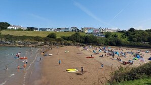 A beach with people, kayaks, and tents. Houses are visible in the background. - 4 Bed in Lampeter (oc-41577) (Cellan)