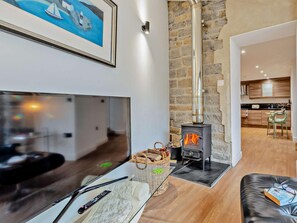 A modern living room with a large flat-screen TV, a fireplace, a wicker basket, and a leather ottoman. - 1 Bed in Langport (oc-41489) (Curry Rivel)