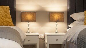 A hotel room with two bedside tables, each with a lamp, a small drawer, and a power outlet. - 2 Bed in Launceston (oc-41992) (Saint Giles on the Heath)