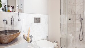 A modern bathroom with a large sink, toilet, and glass-enclosed shower. - VISIONAPARTMENTS Frankfurt self check-in (Frankfurt am Main)