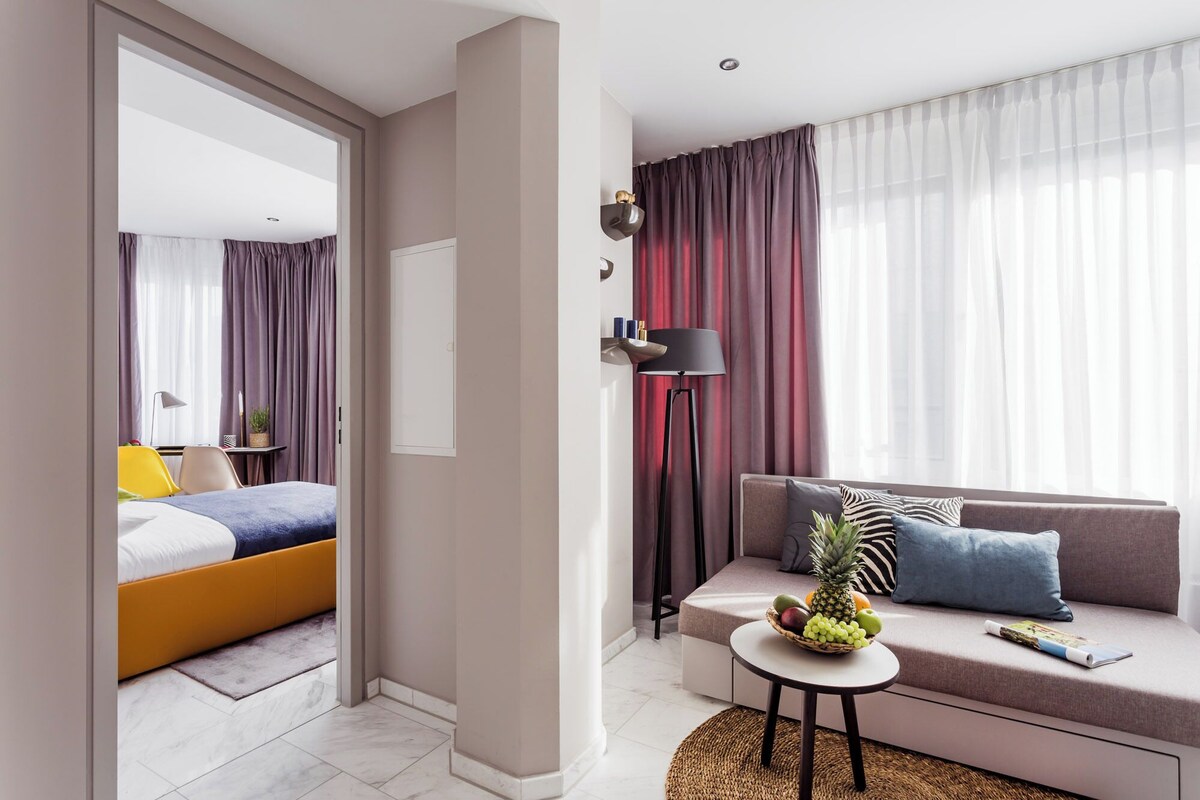 Ein Hotelzimmer mit Bett, einer Couch, einem kleinen Tisch und einer Stehlampe.