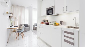 A modern kitchen with white cabinetry, a built-in microwave, and a sink. - VISIONAPARTMENTS Frankfurt self check-in (Frankfurt am Main)